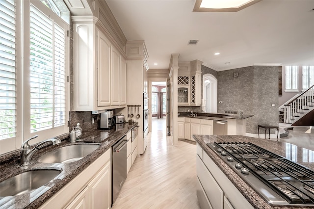 kitchen featuring sink, dark stone countertops, stainless steel appliances, tasteful backsplash, and white cabinets