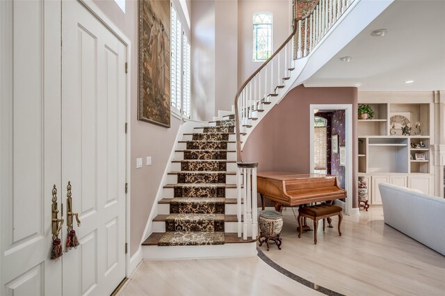 staircase with hardwood / wood-style flooring and a towering ceiling