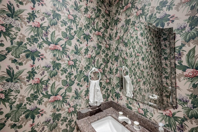 bathroom featuring vanity and wallpapered walls