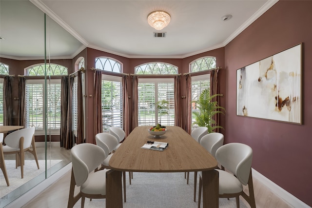 dining area featuring baseboards, visible vents, and crown molding