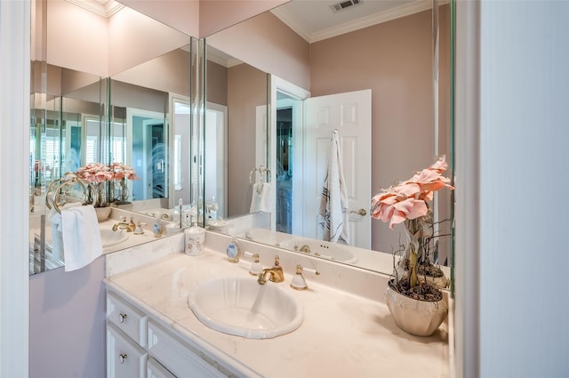 bathroom featuring visible vents, crown molding, and vanity