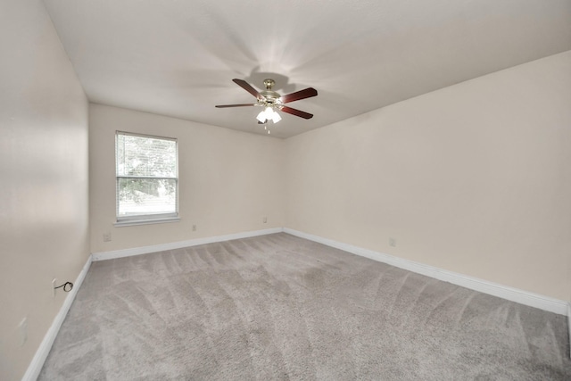 spare room featuring light carpet and ceiling fan