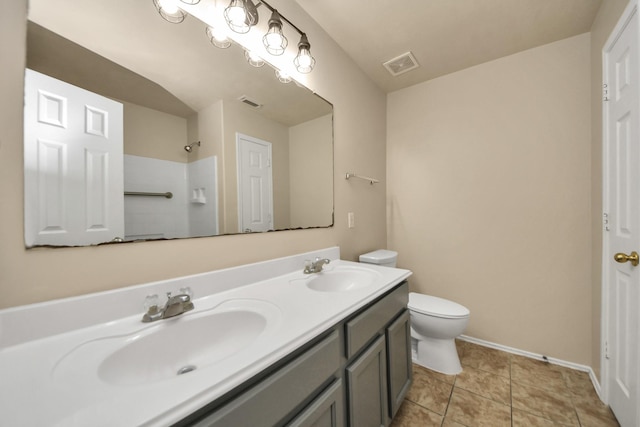 bathroom with tile patterned flooring, vanity, toilet, and walk in shower