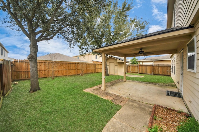 view of yard with ceiling fan, a storage unit, and a patio