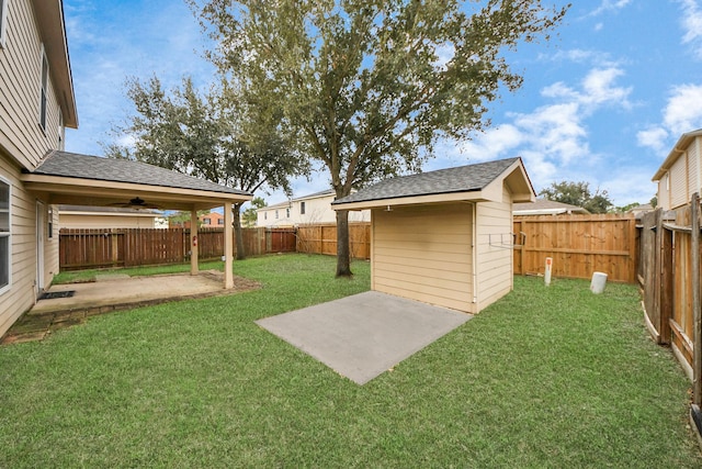 view of yard featuring a patio, ceiling fan, and a shed