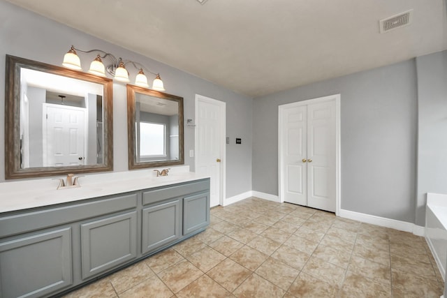 bathroom with vanity, tile patterned flooring, and a tub