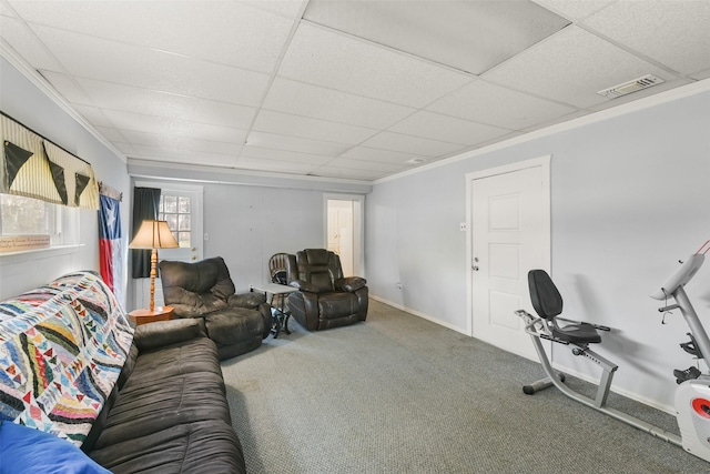 living room featuring a drop ceiling, carpet floors, and ornamental molding