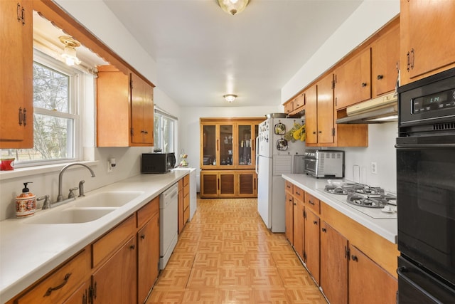 kitchen featuring sink, light parquet floors, and black appliances