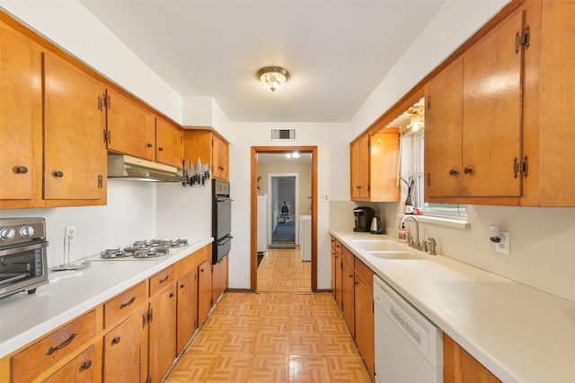 kitchen featuring sink, white appliances, washer / clothes dryer, and light parquet floors