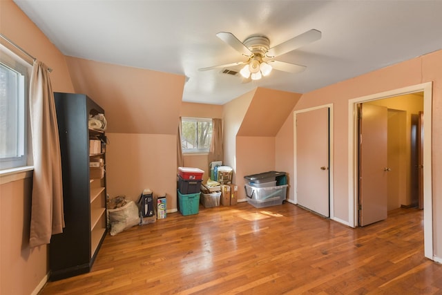 additional living space with vaulted ceiling, hardwood / wood-style floors, and ceiling fan