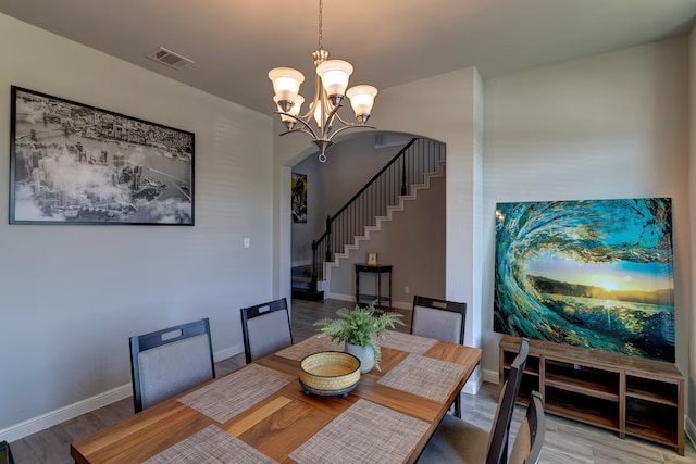 dining area featuring wood-type flooring and a notable chandelier