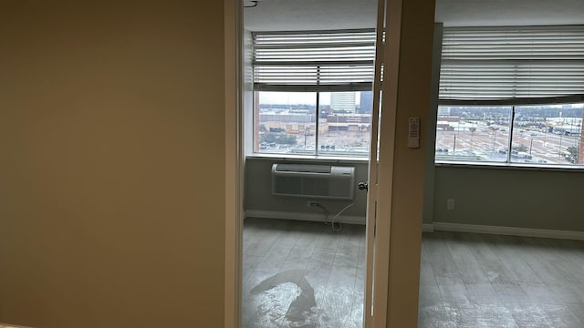 doorway with hardwood / wood-style floors and a wall unit AC