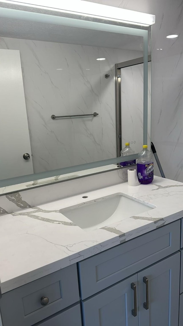 bathroom with vanity and tiled shower