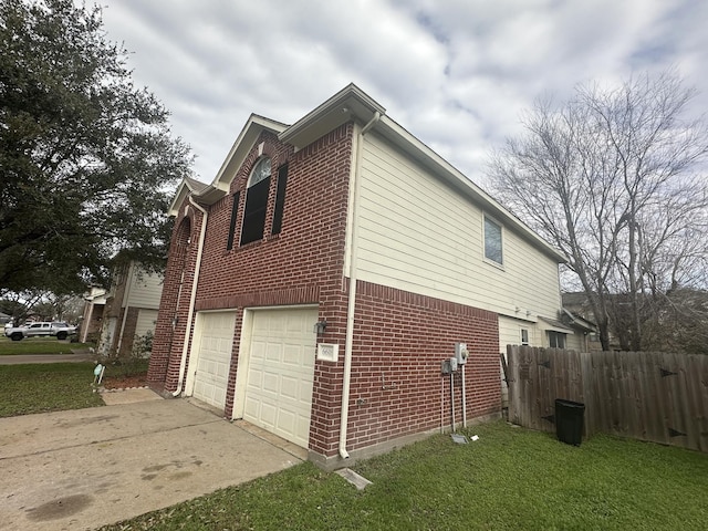 view of side of home featuring a garage and a lawn