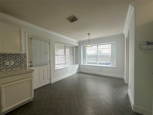 unfurnished dining area with ornamental molding, dark parquet floors, and a textured ceiling