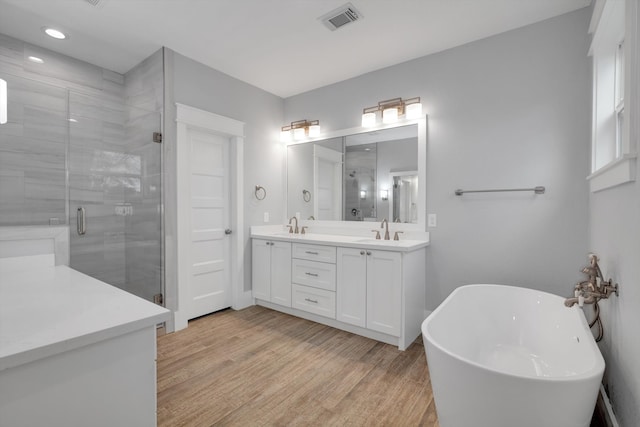 bathroom featuring hardwood / wood-style flooring, vanity, and separate shower and tub