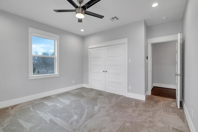 unfurnished bedroom with light carpet, ceiling fan, and a closet