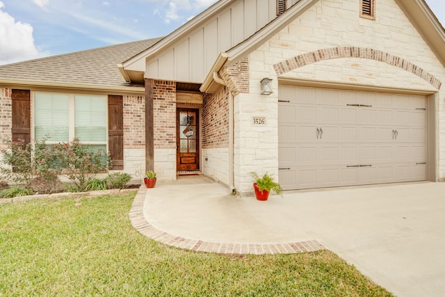 entrance to property featuring a garage and a yard