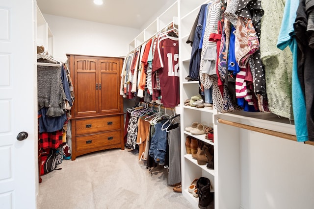 walk in closet featuring light colored carpet