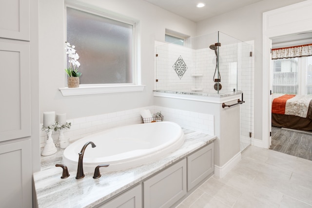 bathroom featuring independent shower and bath and tile patterned flooring