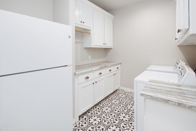 washroom with separate washer and dryer, light tile patterned floors, and cabinets