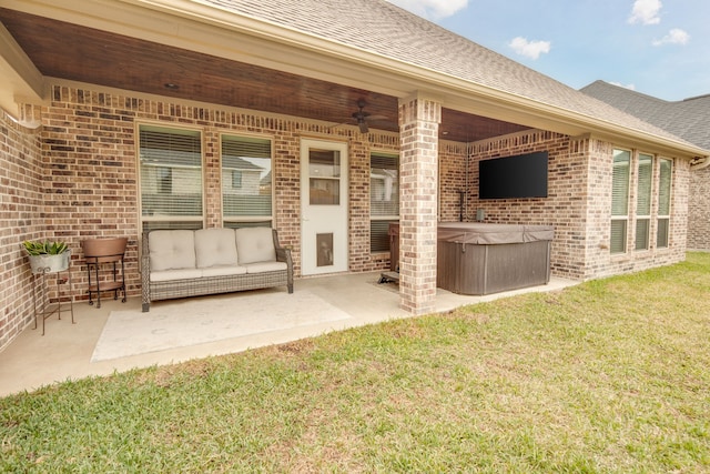 view of patio / terrace with ceiling fan and a hot tub