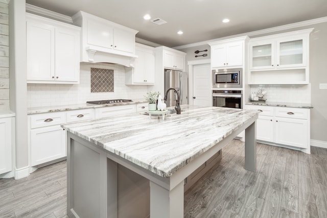 kitchen with white cabinetry, a center island with sink, and appliances with stainless steel finishes