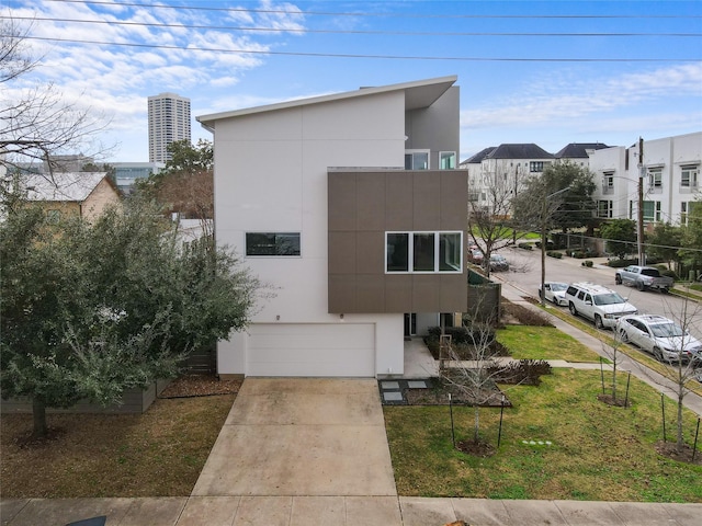 modern home featuring a garage and a front lawn