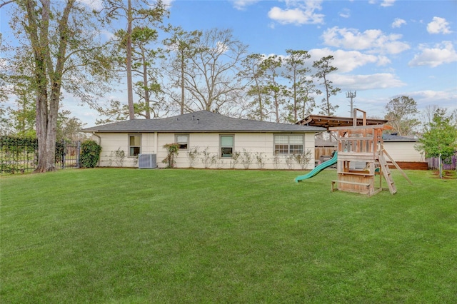 back of property with a yard, a playground, and central air condition unit