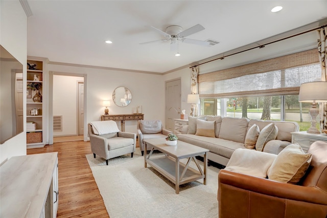 living room with ornamental molding, light hardwood / wood-style floors, and ceiling fan