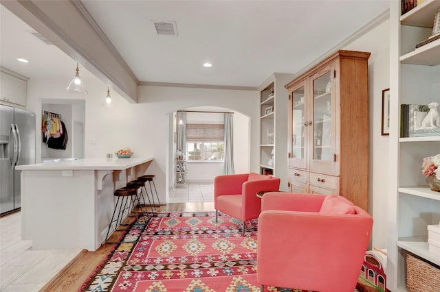 living room with ornamental molding and light hardwood / wood-style flooring