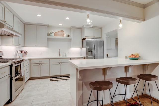 kitchen with white cabinetry, sink, a kitchen breakfast bar, hanging light fixtures, and stainless steel appliances