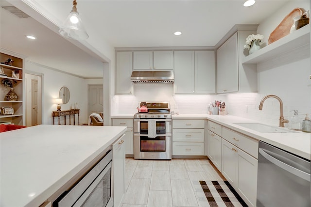 kitchen with sink, decorative light fixtures, stainless steel appliances, and white cabinets