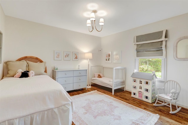 bedroom featuring a notable chandelier and hardwood / wood-style flooring