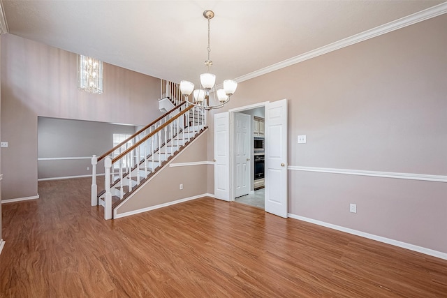 interior space with an inviting chandelier, crown molding, and hardwood / wood-style floors