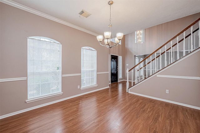 entryway featuring crown molding, wood-type flooring, and a chandelier