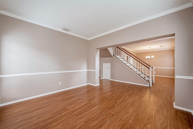 unfurnished living room featuring hardwood / wood-style flooring, ornamental molding, and a notable chandelier