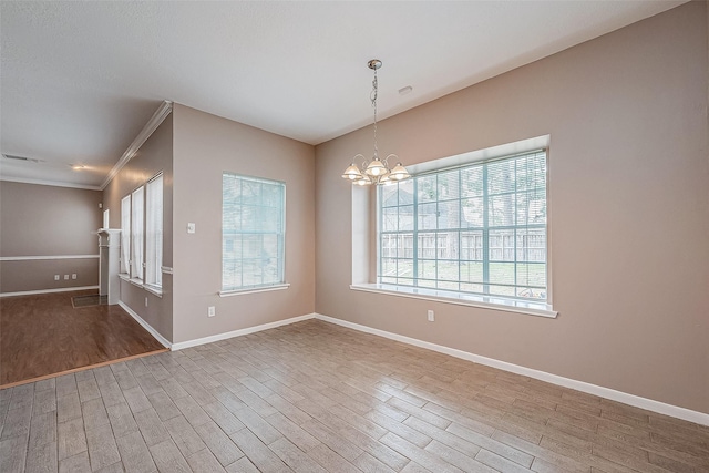 spare room with an inviting chandelier, wood-type flooring, and ornamental molding