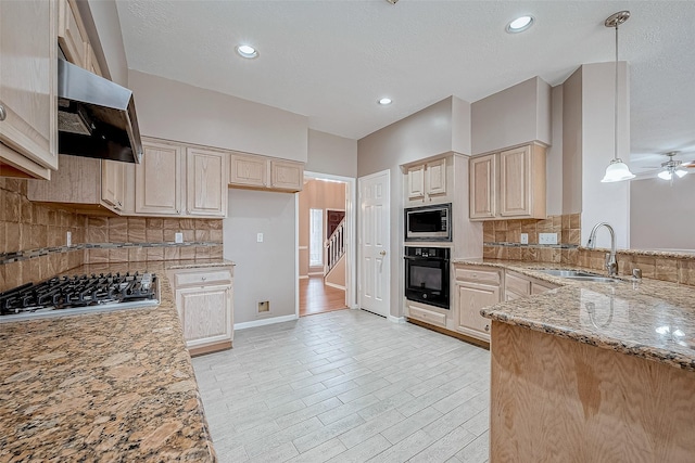 kitchen with sink, decorative light fixtures, ventilation hood, stainless steel appliances, and light stone countertops