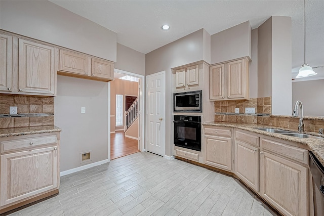 kitchen featuring hanging light fixtures, light stone countertops, appliances with stainless steel finishes, and sink