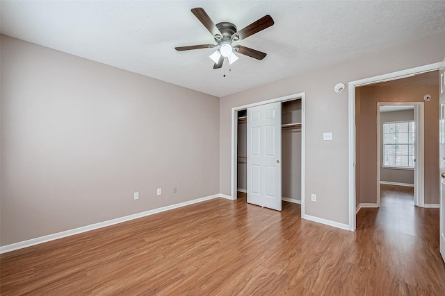 unfurnished bedroom with ceiling fan, light hardwood / wood-style floors, a closet, and a textured ceiling