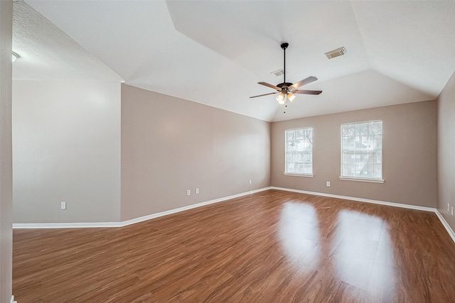 empty room with ceiling fan, lofted ceiling, and wood-type flooring