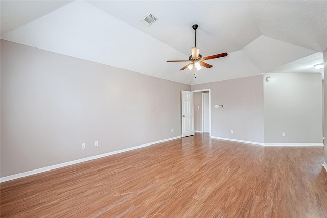 empty room featuring ceiling fan, vaulted ceiling, and light wood-type flooring