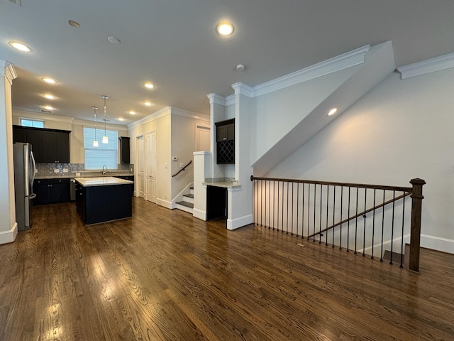 kitchen with crown molding, stainless steel fridge, backsplash, dark hardwood / wood-style floors, and a kitchen island