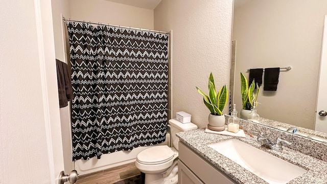 full bathroom featuring vanity, hardwood / wood-style floors, shower / tub combo with curtain, and toilet