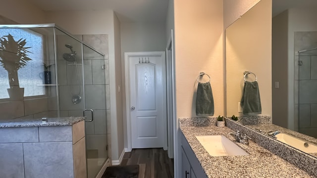 bathroom with hardwood / wood-style flooring, vanity, and an enclosed shower