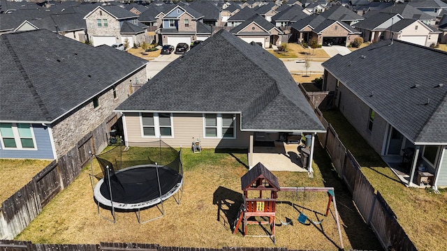 back of property with a playground, a yard, and a trampoline