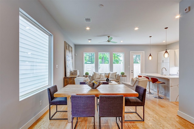 dining space with sink, light hardwood / wood-style flooring, and ceiling fan