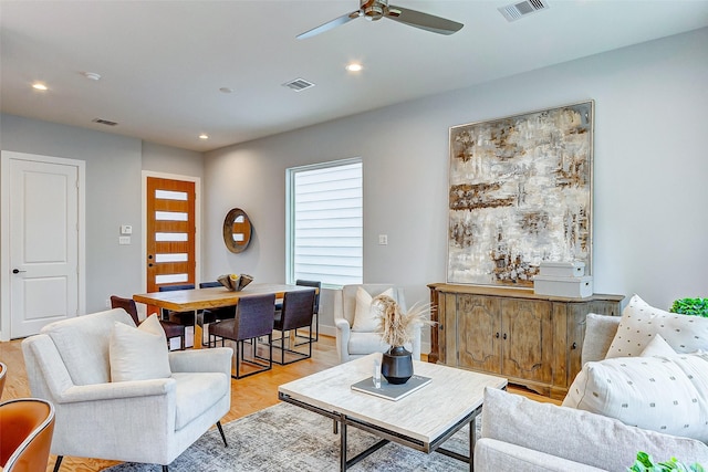 living room with light hardwood / wood-style flooring and ceiling fan