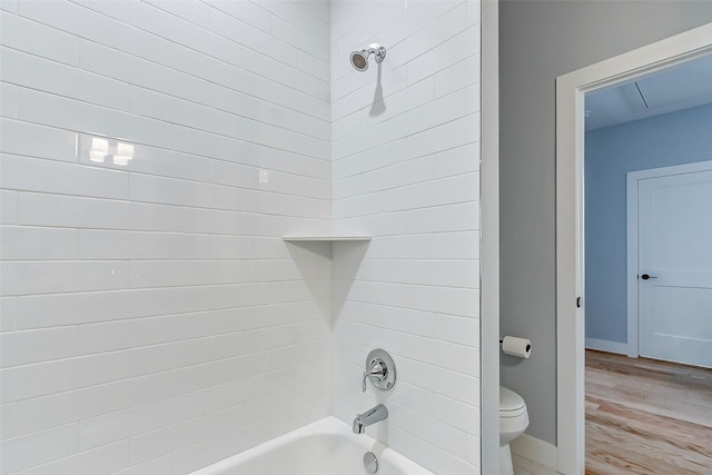 bathroom featuring tiled shower / bath, wood-type flooring, and toilet